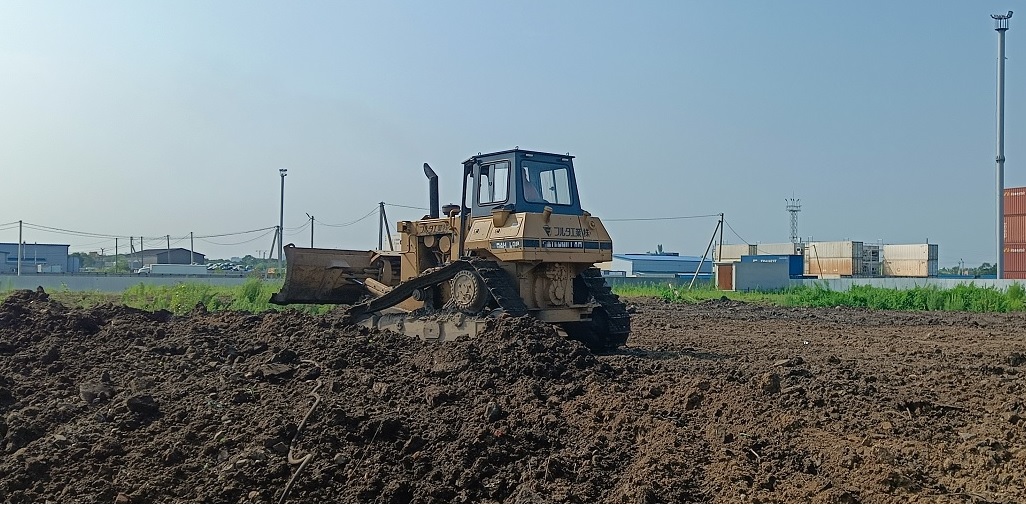 Бульдозер и экскватор роют и копают котлованы в Биробиджане